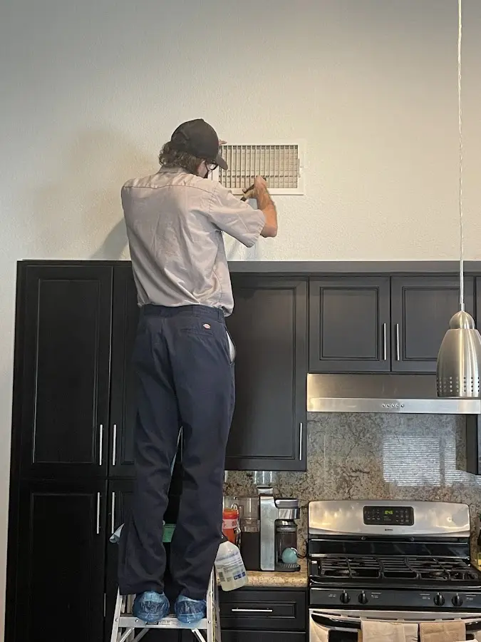 Technician inspecting an air vent during HVAC service in Hemet